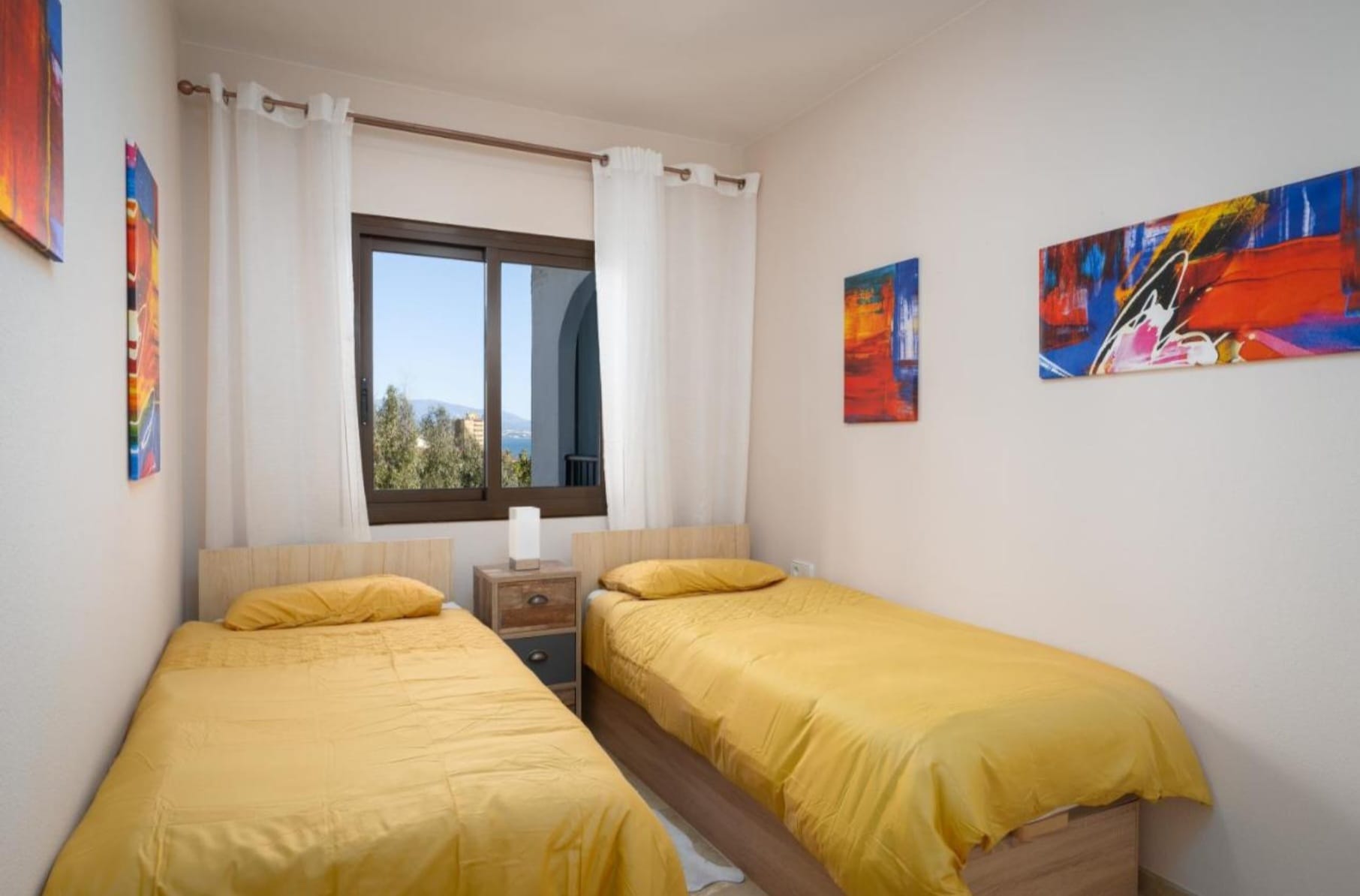 Twin bedroom with natural light and two single beds in Marina de la Duquesa holiday rental apartment